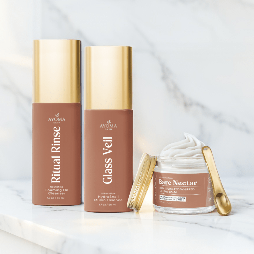 Ayoma Skin Glass Skin Glow Trio—Ritual Rinse, Glass Veil, Bare Nectar on marble, gold accents.