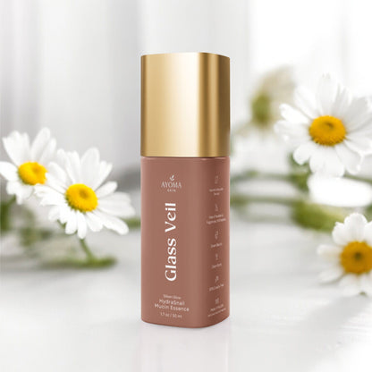 Skincare bottle labeled 'Glass Veil' with a gold cap on a white background with daisies.